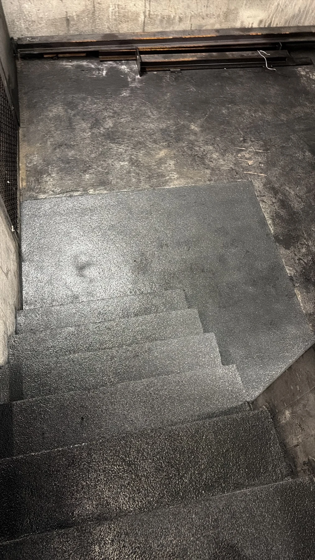 Anthrazit beschichtete Industrietreppe mit strukturierter Oberfläche und anschließendem Podest
