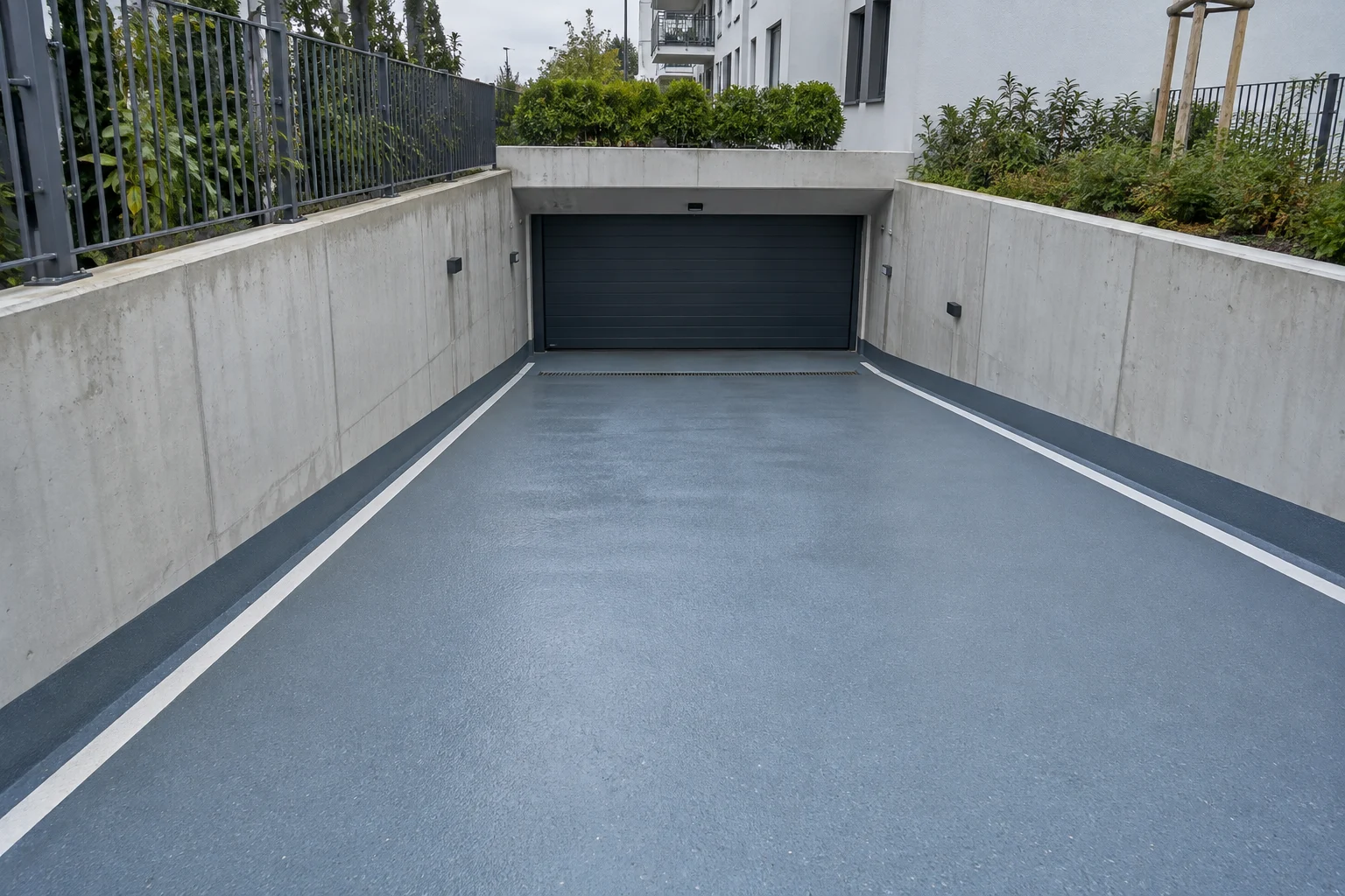 Geneigte Tiefgaragenzufahrt mit griffiger Beschichtung und Entwässerungsrinne